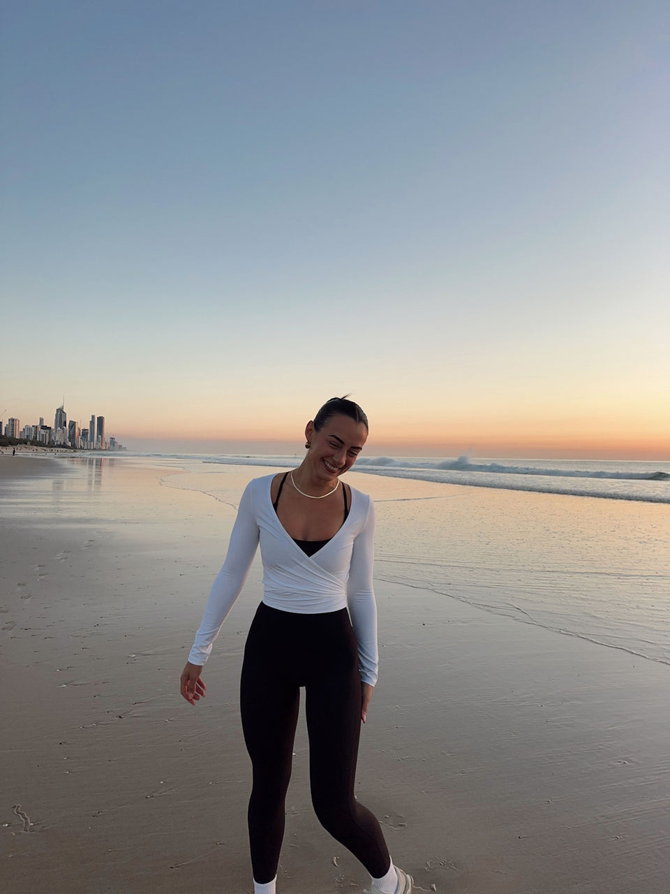@christinapengilly wearing Aura Peachy Invisible Scrunch Ankle Leggings in Black and Bliss Wrap Top in White