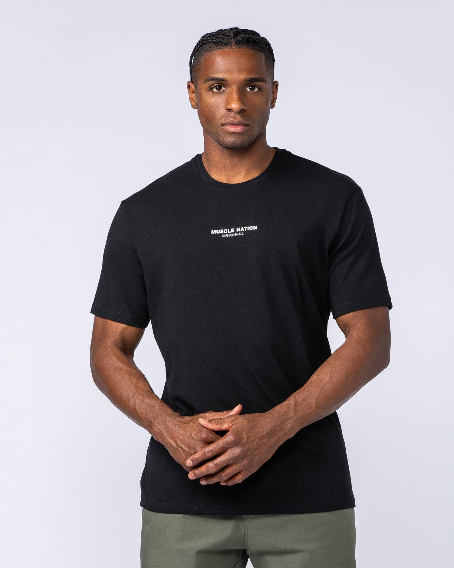Male model wearing the black Staple Condition Tee, front view - regular-fit cotton tee with Muscle Nation Original chest logo