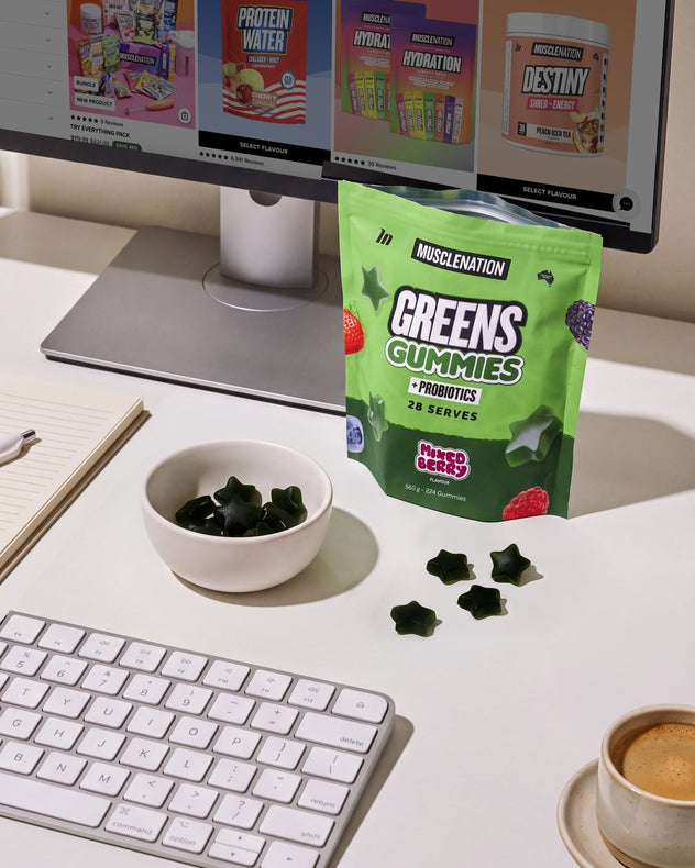 A pouch of Greens Gummies and a bowl of gummies on a work desk