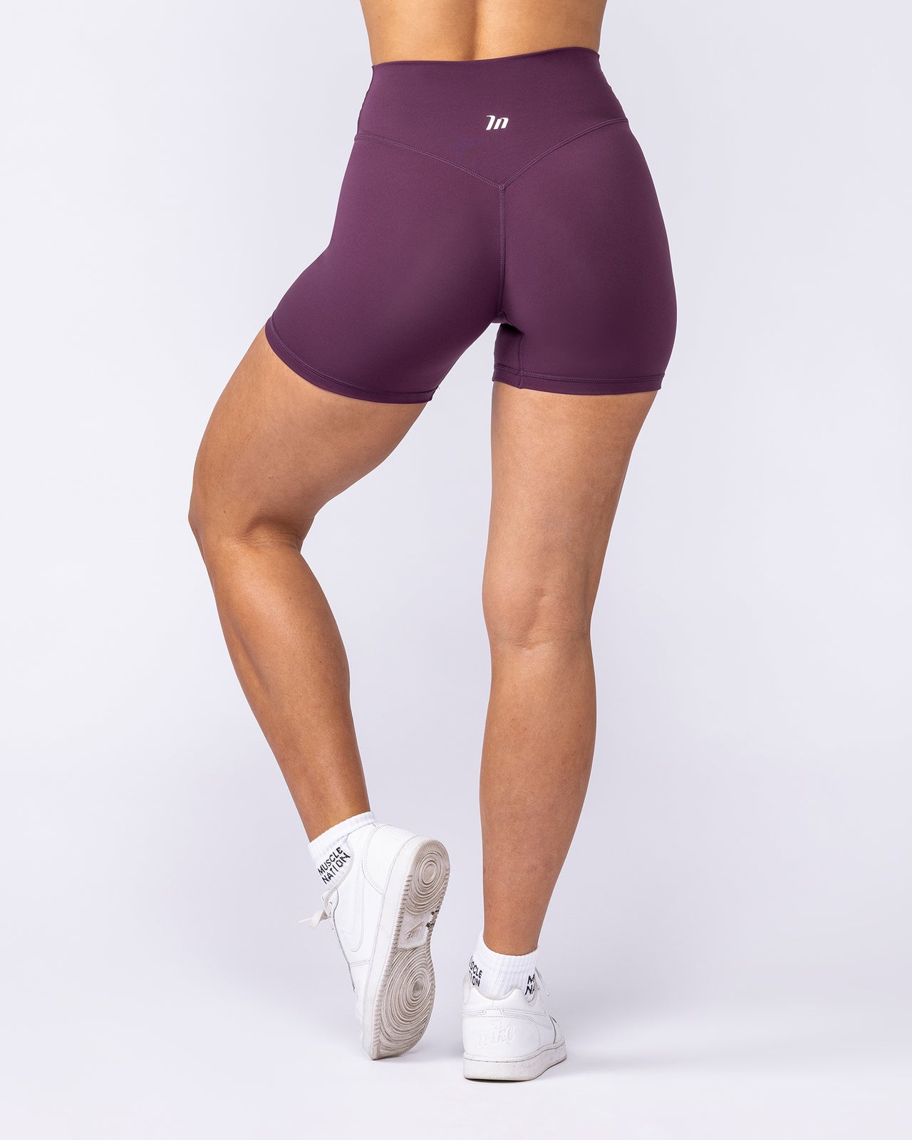 Purple athletic shorts worn by a person on a white background
