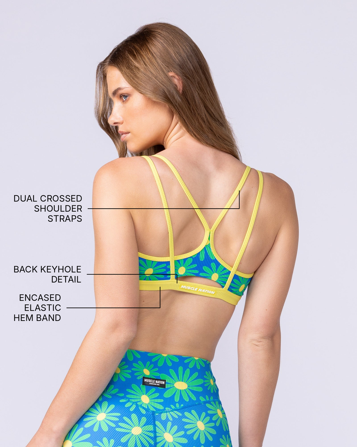 Pace It Rib Bra - Malibu Petals - Muscle Nation feature callouts: dual crossed shoulder straps, back keyhole detail, encased elastic hem band