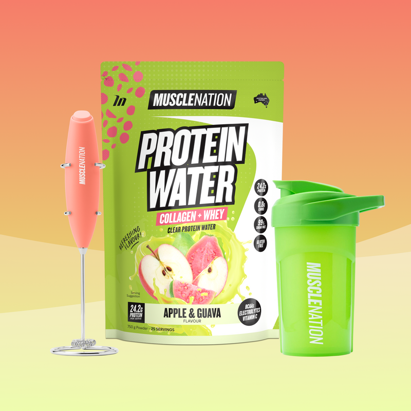 MuscleNation Protein Water pouch in apple & guava flavor, shown with a pink handheld milk frother and a bright green shaker bottle on a soft peach-to-yellow gradient background.